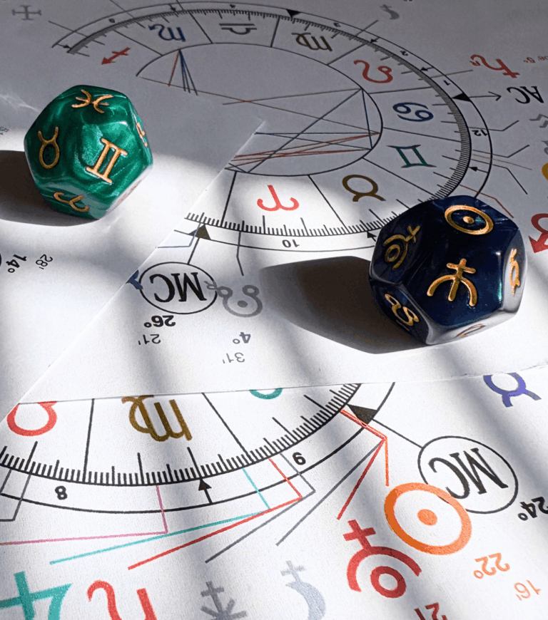 Thème astral posé sur une table avec des dés astrologiques