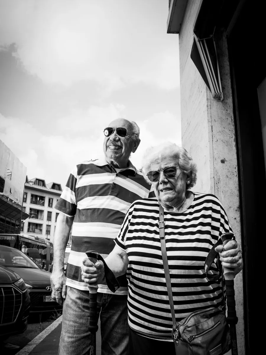 Un couple âgé en marinières assorties et lunettes de soleil, qui rit