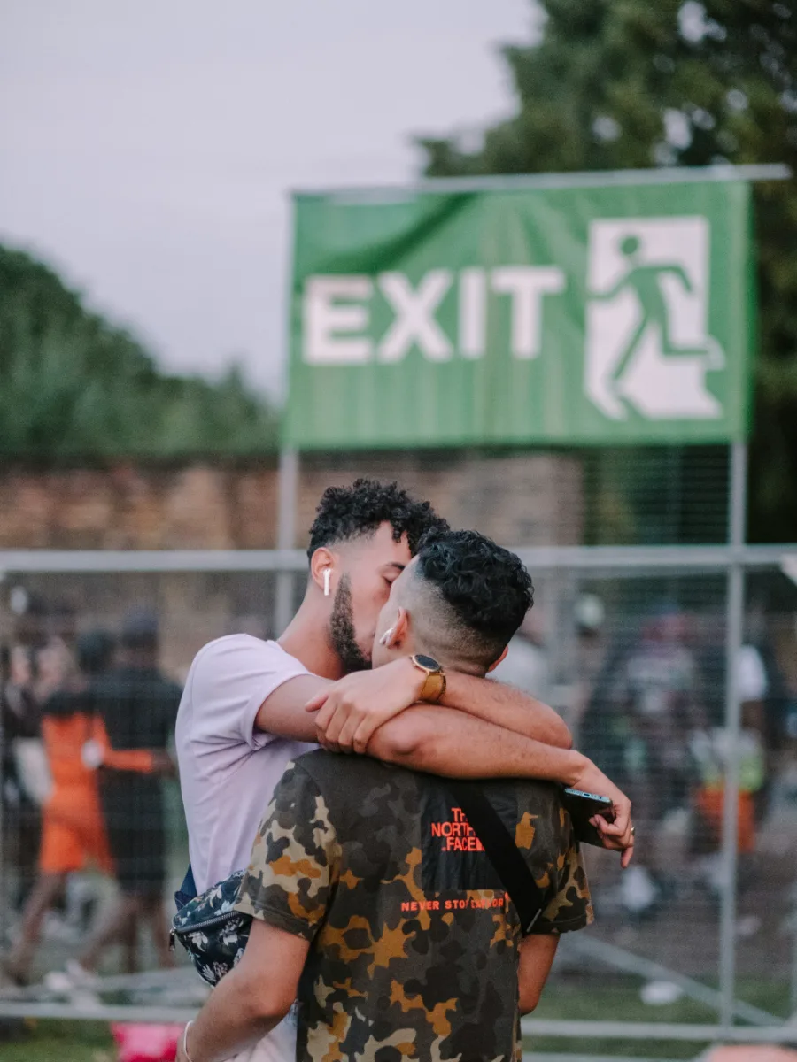 Deux hommes enlacés sous un panneau EXIT