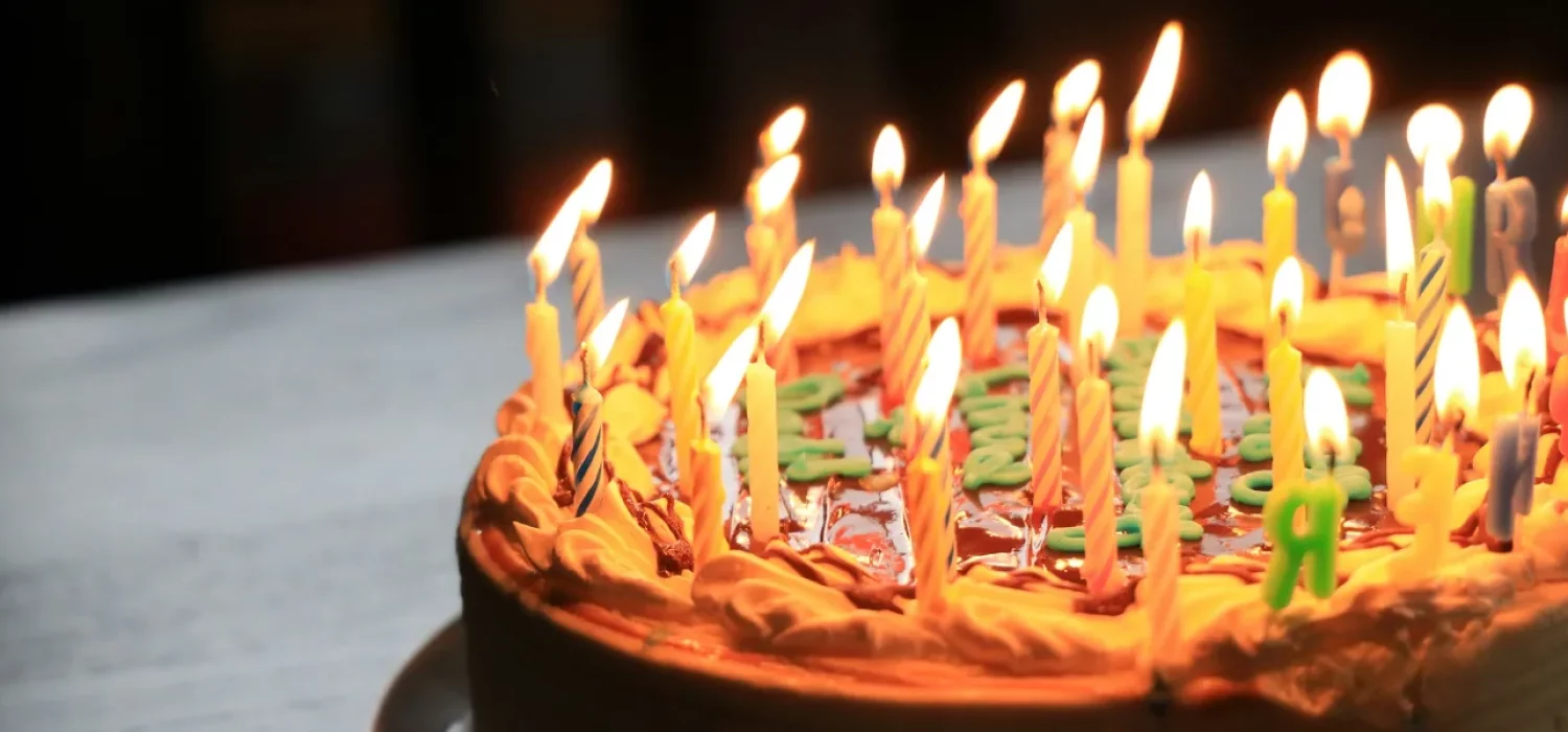 Un gâteau d’anniversaire couvert de bougies allumées