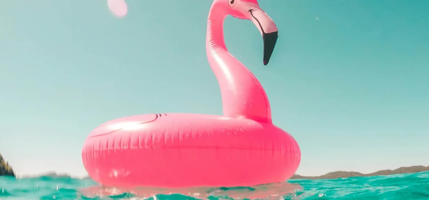 Bouée flamant rose qui flotte sur une mer turquoise